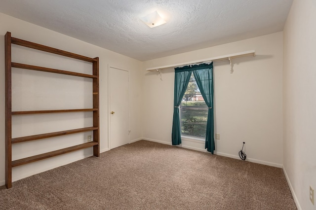 spare room featuring carpet floors and a textured ceiling