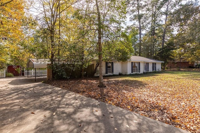 ranch-style home with concrete driveway and a detached carport