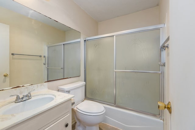 full bathroom with enclosed tub / shower combo, vanity, and toilet