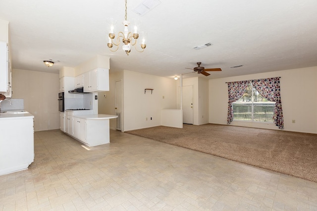 unfurnished living room with ceiling fan with notable chandelier, sink, light colored carpet, and a textured ceiling