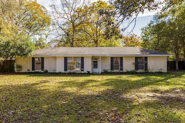 ranch-style house featuring a front yard, brick siding, and fence