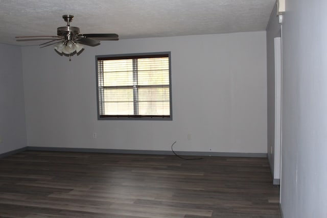 empty room with dark wood finished floors, baseboards, a textured ceiling, and a ceiling fan