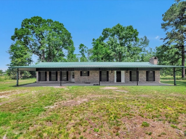 315 Circle G Ln, Huntington, TX 75949 - rear view of property with a chimney, a lawn, brick siding, metal roof, and a patio area