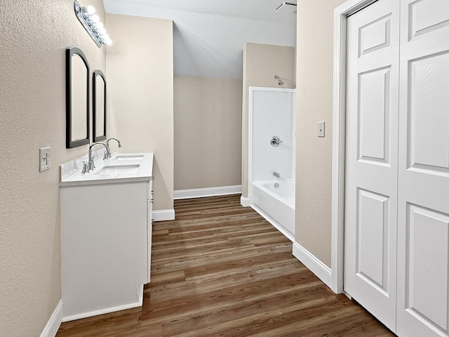 4124 N US Highway 96, Jasper, TX 75951 - full bath featuring wood finished floors, double vanity, a textured wall, shower / bathtub combination, and a closet