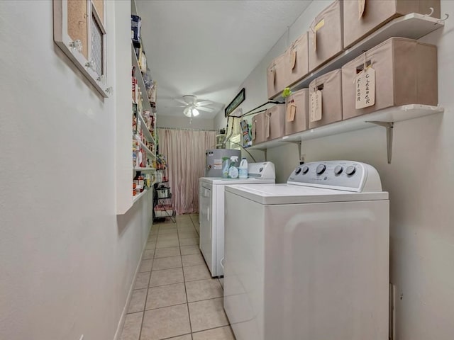 laundry area featuring electric water heater, washing machine and dryer, light tile patterned floors, laundry area, and a ceiling fan