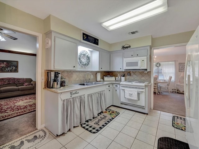 kitchen with white appliances, light tile patterned floors, visible vents, a sink, and light countertops