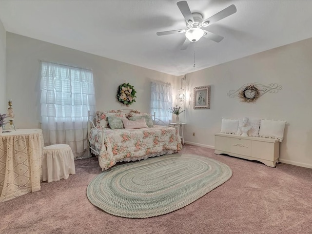 carpeted bedroom with a ceiling fan and baseboards