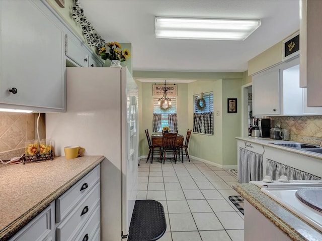 kitchen featuring white cabinetry, light countertops, light tile patterned flooring, and tasteful backsplash