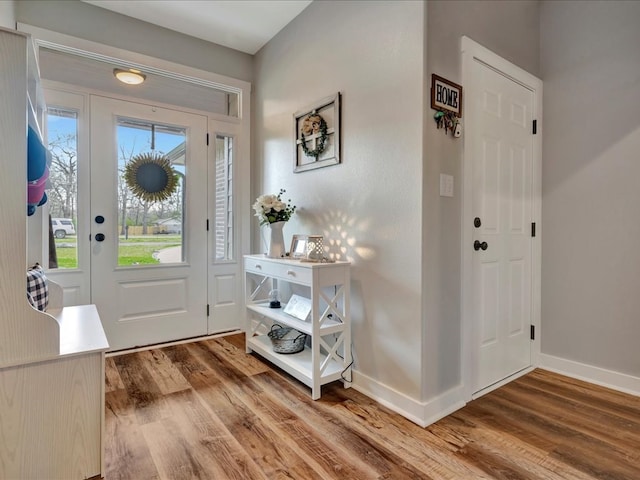 foyer featuring baseboards and wood finished floors