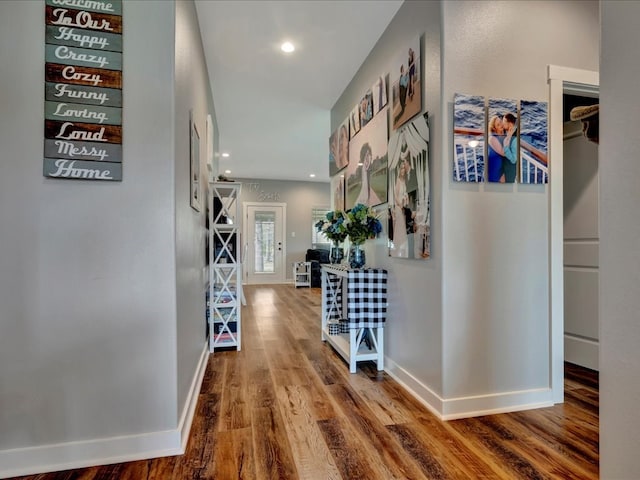 hall featuring recessed lighting, baseboards, and wood finished floors