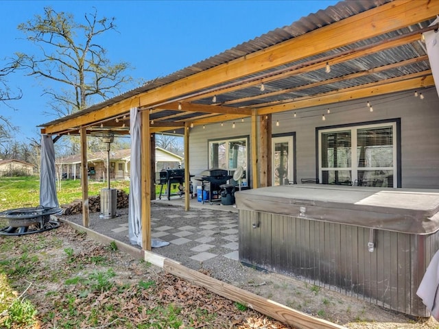 view of patio featuring central AC unit, an outdoor fire pit, area for grilling, and a hot tub