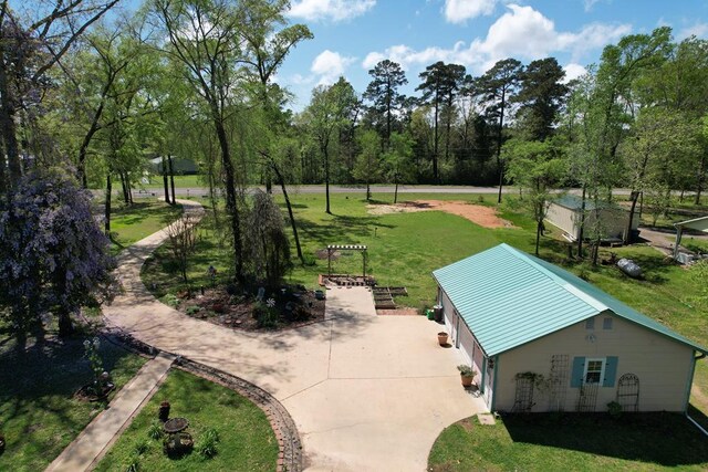 9097 Fm 83 W, Broaddus, TX 75929 - rear view of house with driveway, a garage, a lawn, and a vegetable garden