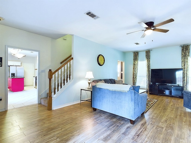 living room featuring a wealth of natural light, ceiling fan, and wood-type flooring