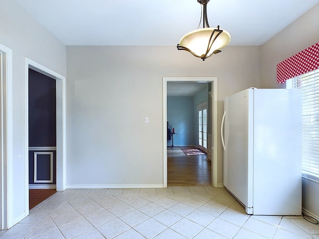 kitchen featuring pendant lighting, white fridge, and light hardwood / wood-style flooring