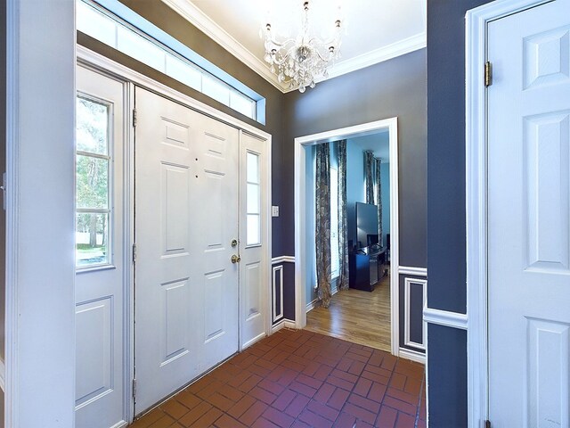 foyer entrance featuring a chandelier and crown molding