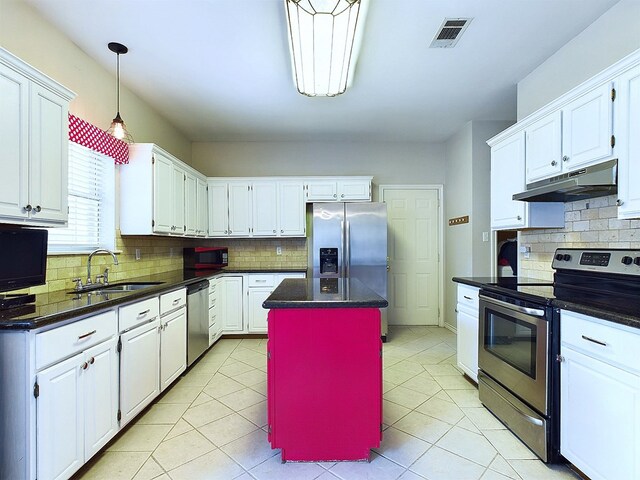 kitchen with appliances with stainless steel finishes, backsplash, a kitchen island, sink, and white cabinetry