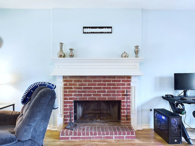 interior details featuring wood-type flooring and a brick fireplace