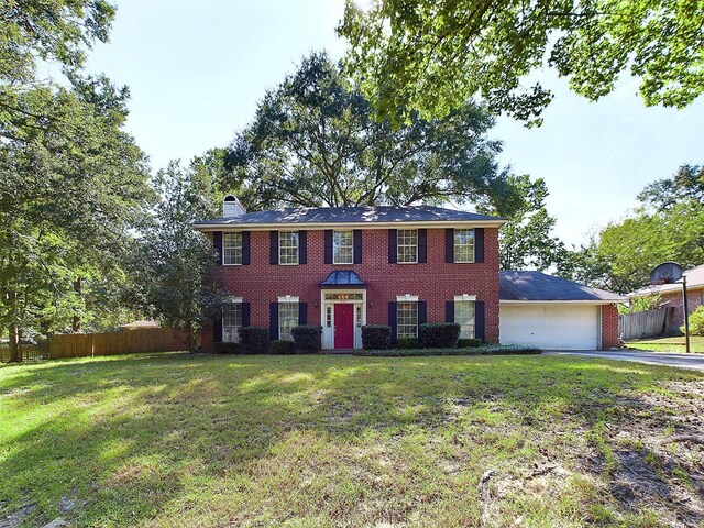 colonial-style house with a garage and a front lawn