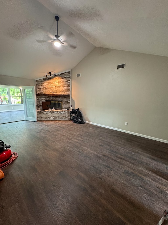 393 Rosewood Dr, Jasper, TX 75951 - unfurnished living room featuring a brick fireplace, a ceiling fan, a textured ceiling, lofted ceiling, and wood finished floors