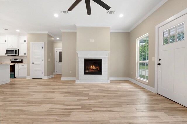 1911 Paul Ave, Lufkin, TX 75901 - unfurnished living room featuring a ceiling fan, ornamental molding, light wood-style flooring, recessed lighting, and a brick fireplace