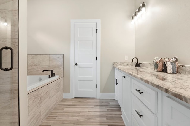 1911 Paul Ave, Lufkin, TX 75901 - bathroom featuring vanity, a garden tub, a stall shower, and wood finished floors
