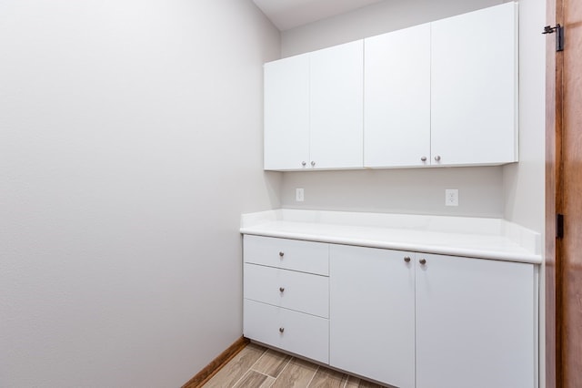 1308 Walnut Bend Dr, Lufkin, TX 75904 - kitchen with light countertops, white cabinetry, light wood-type flooring, and baseboards