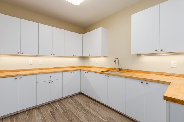 1308 Walnut Bend Dr, Lufkin, TX 75904 - kitchen featuring butcher block countertops, a sink, and white cabinetry