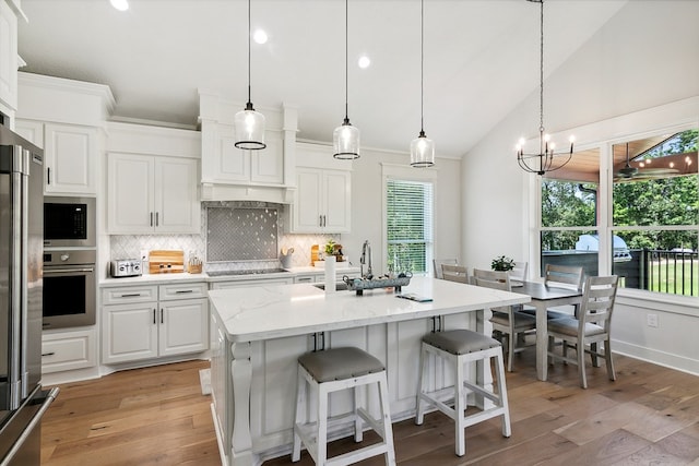 175 Vantage Dr, Brookeland, TX 75931 - kitchen featuring stainless steel appliances, a sink, decorative backsplash, white cabinetry, and light wood-type flooring