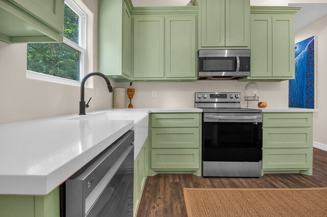 140 Spruce Ln, Brookeland, TX 75931 - kitchen with appliances with stainless steel finishes, green cabinetry, dark wood finished floors, and light countertops