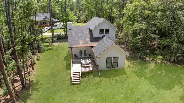 140 Spruce Ln, Brookeland, TX 75931 - rear view of house featuring roof with shingles, a deck, a chimney, and a lawn