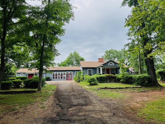 905 Fm 353, San Augustine, TX 75972 - view of front of house featuring a chimney and aphalt driveway