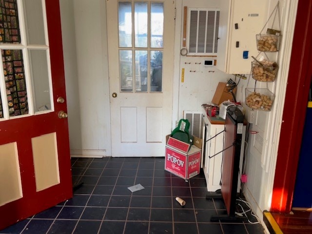 doorway with dark tile patterned flooring