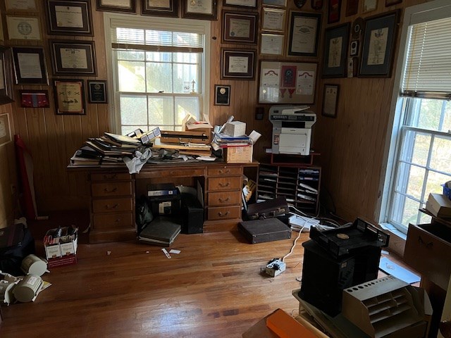 office space with hardwood / wood-style floors, plenty of natural light, and wooden walls