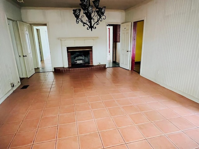 905 Fm 353, San Augustine, TX 75972 - unfurnished living room featuring a notable chandelier, tile patterned flooring, a fireplace, and visible vents