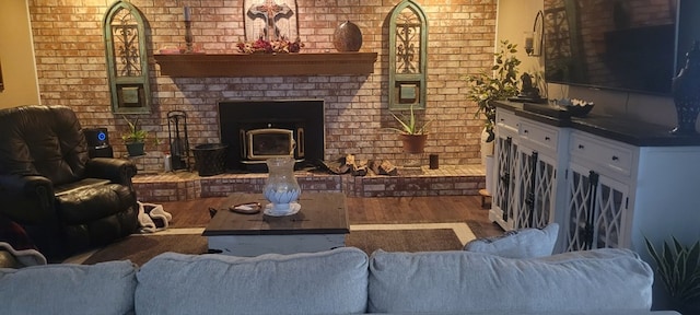 living room with brick wall and wood finished floors