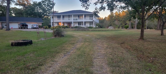 rear view of property featuring a lawn and a balcony