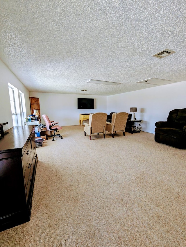 interior space with carpet, visible vents, and a textured ceiling