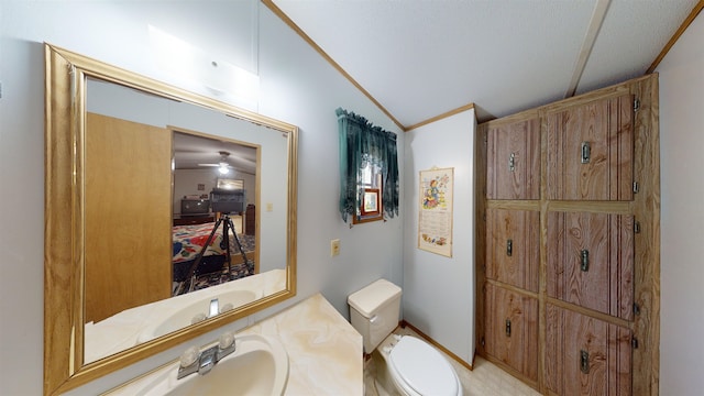 bathroom with ceiling fan, crown molding, vaulted ceiling, toilet, and vanity