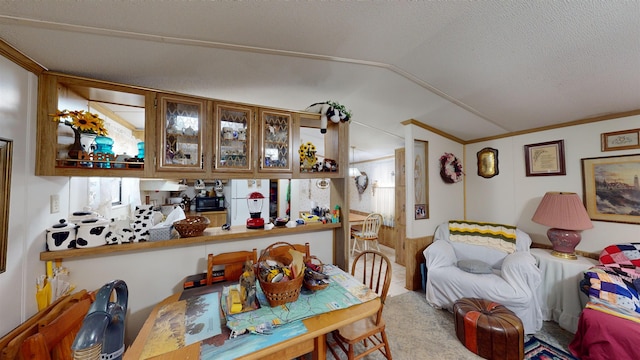 dining space featuring a textured ceiling, crown molding, and lofted ceiling