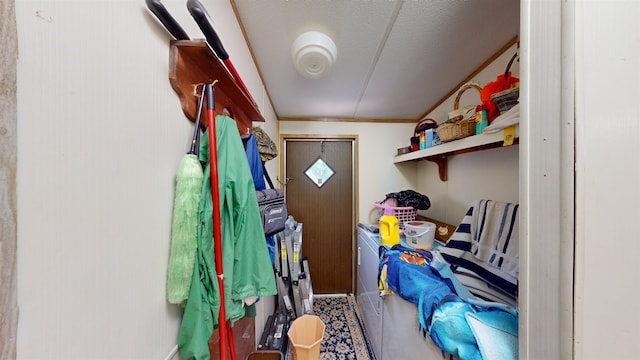 washroom with a textured ceiling, washer and dryer, and crown molding