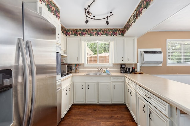 1405 Cimmarron St, Lufkin, TX 75904 - kitchen with appliances with stainless steel finishes, a sink, a wall mounted air conditioner, white cabinetry, and light countertops