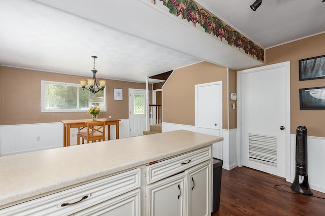 1405 Cimmarron St, Lufkin, TX 75904 - kitchen with a chandelier, hanging light fixtures, dark wood-type flooring, light countertops, and wainscoting