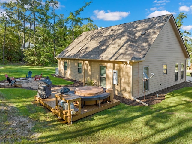 185 Ashley Dr, Brookeland, TX 75931 - back of property featuring a fire pit, a wooden deck, a hot tub, and a yard
