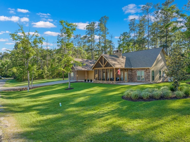 185 Ashley Dr, Brookeland, TX 75931 - view of front facade with a front yard, a chimney, and stone siding