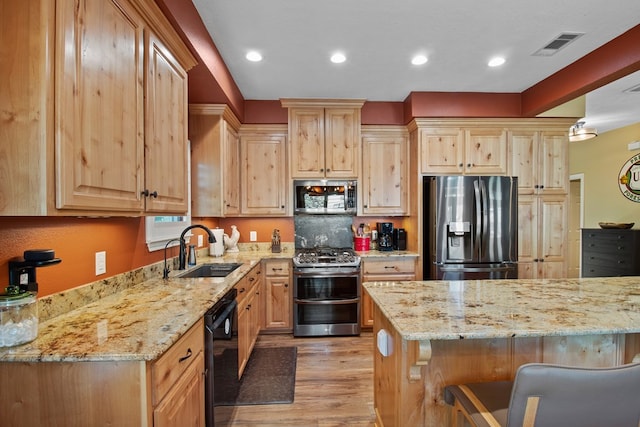 185 Ashley Dr, Brookeland, TX 75931 - kitchen featuring appliances with stainless steel finishes, a sink, light brown cabinets, light wood-type flooring, and recessed lighting