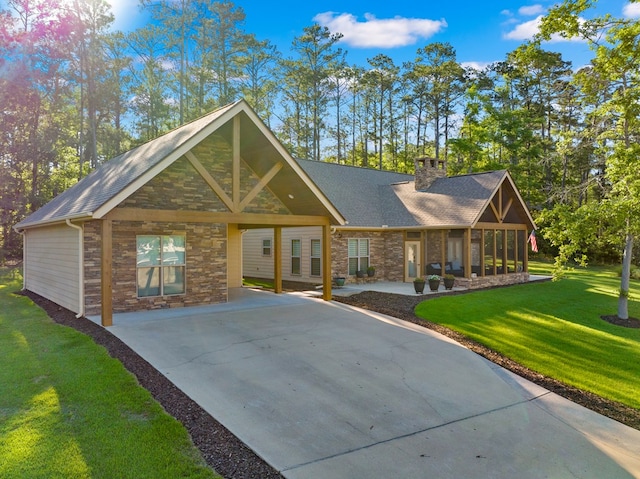 185 Ashley Dr, Brookeland, TX 75931 - view of front of home featuring concrete driveway, stone siding, a front lawn, and a chimney