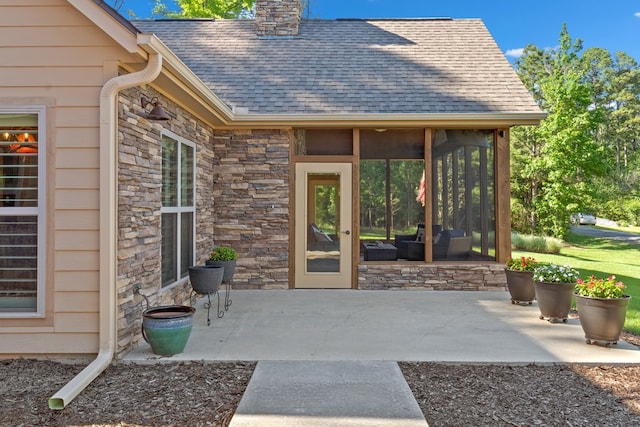 185 Ashley Dr, Brookeland, TX 75931 - view of exterior entry featuring stone siding, roof with shingles, a patio, and a chimney