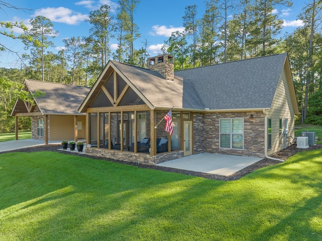 185 Ashley Dr, Brookeland, TX 75931 - rear view of property with a sunroom, stone siding, a chimney, central AC, and a lawn