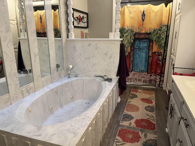 bathroom featuring a tub to relax in, vanity, and wood-type flooring