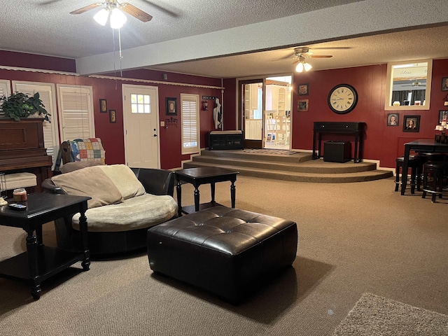 carpeted living room with ceiling fan and a textured ceiling